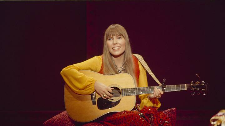 Joni Mitchell holding a guitar