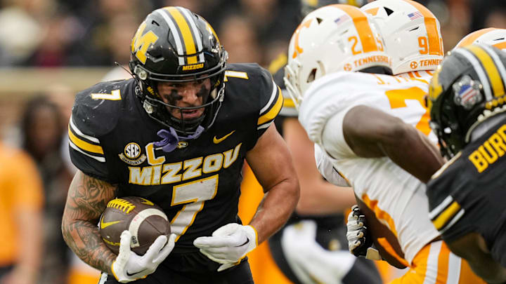 Nov 11, 2023; Columbia, Missouri, USA; Missouri Tigers running back Cody Schrader (7) runs the ball against Tennessee Volunteers defensive back Jourdan Thomas (25) during the first half at Faurot Field at Memorial Stadium. Mandatory Credit: Jay Biggerstaff-Imagn Images