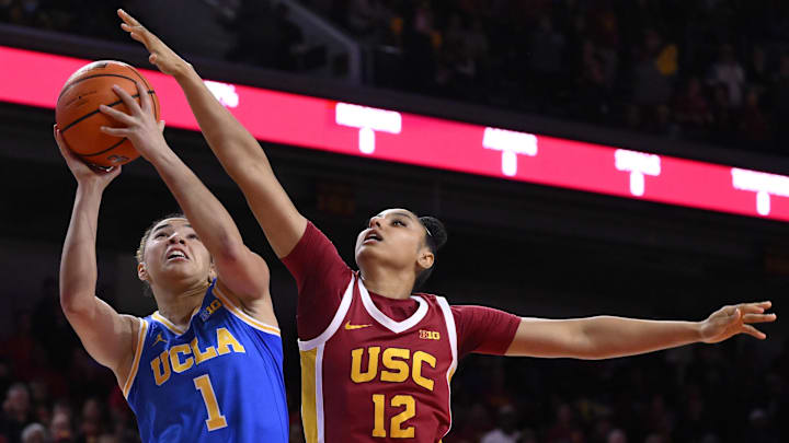 Feb 13, 2025; Los Angeles, California, USA; UCLA Bruins guard Kiki Rice (1) drives to the basket against USC Trojans guard JuJu Watkins (12).
