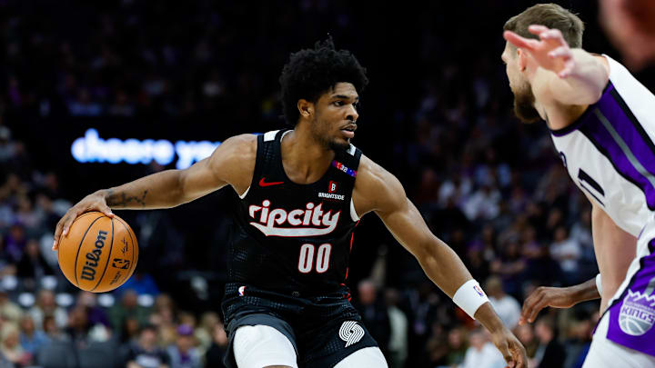 Mar 27, 2025; Sacramento, California, USA; Portland Trail Blazers guard Scoot Henderson (00) dribbles against Sacramento Kings forward Domantas Sabonis (11) during the third quarter at Golden 1 Center. Mandatory Credit: Sergio Estrada-Imagn Images