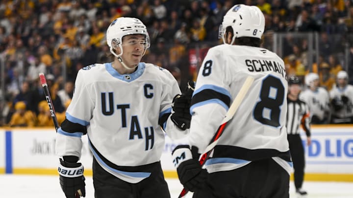Apr 14, 2025; Nashville, Tennessee, USA;  Utah Hockey Club center Nick Schmaltz (8) celebrates a goal with center Clayton Keller (9) against the Nashville Predators during the second period at Bridgestone Arena. Mandatory Credit: Steve Roberts-Imagn Images