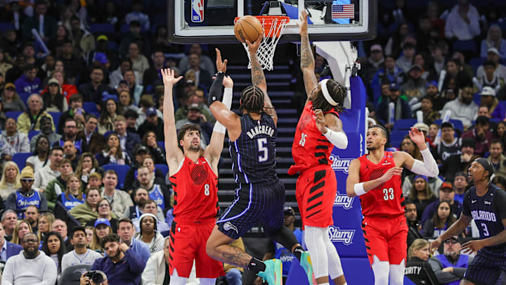 Jan 23, 2025; Orlando, Florida, USA; Orlando Magic forward Paolo Banchero (5) shoots against Portland Trail Blazers forward Deni Avdija (8) and center Robert Williams III (35) during the second half at Kia Center. Mandatory Credit: Mike Watters-Imagn Images