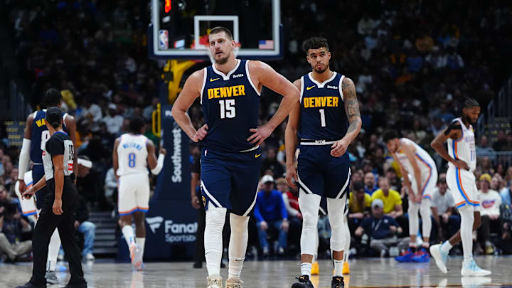 Nov 6, 2024; Denver, Colorado, USA; Denver Nuggets center Nikola Jokic (15) and Denver Nuggets forward Michael Porter Jr. (1)  during a time out ihe first quarter against the Oklahoma City Thunder at Ball Arena. Mandatory Credit: Ron Chenoy-Imagn Images