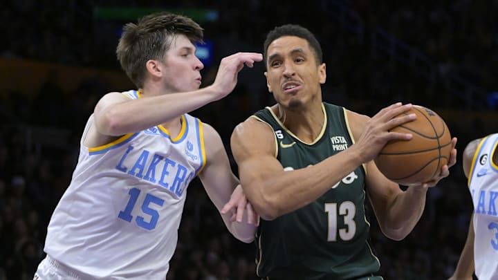 Dec 13, 2022; Los Angeles, California, USA;  Los Angeles Lakers guard Austin Reaves (15) defends Boston Celtics guard Malcolm Brogdon (13) as he moves to the basket in the first half at Crypto.com Arena. Mandatory Credit: Jayne Kamin-Oncea-Imagn Images