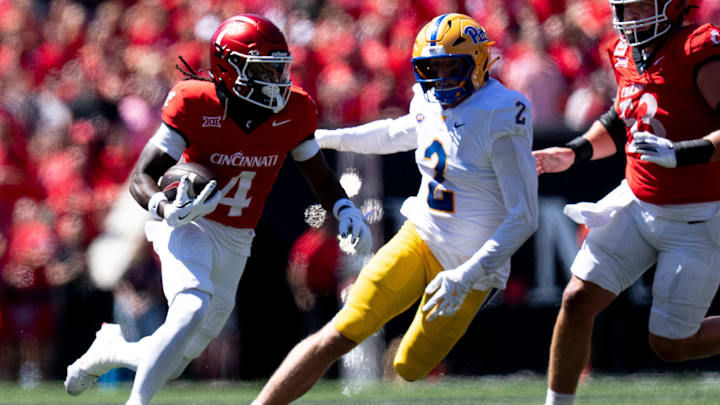 Cincinnati Bearcats wide receiver Tyrin Smith (4) runs as Pittsburgh Panthers defensive lineman Nate Matlack (2) attempts to stop him in the second quarter of the College Football game at Nippert Stadium in Cincinnati on Saturday, Sept. 7, 2024.