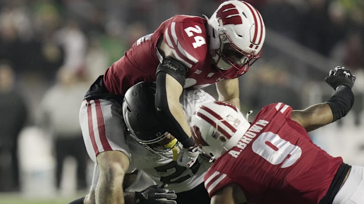 Nov 16, 2024; Madison, Wisconsin, USA; Wisconsin Badgers safety Hunter Wohler (24) tackles Oregon Ducks running back Da'Jaun Riggs (21) during the fourth quarter at Camp Randall Stadium.