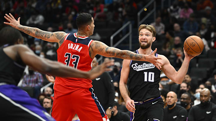 Feb 12, 2022; Washington, District of Columbia, USA; Sacramento Kings forward Domantas Sabonis (10) looks to pass as Washington Wizards forward Kyle Kuzma (33) defends during the first half at Capital One Arena. Mandatory Credit: Brad Mills-Imagn Images