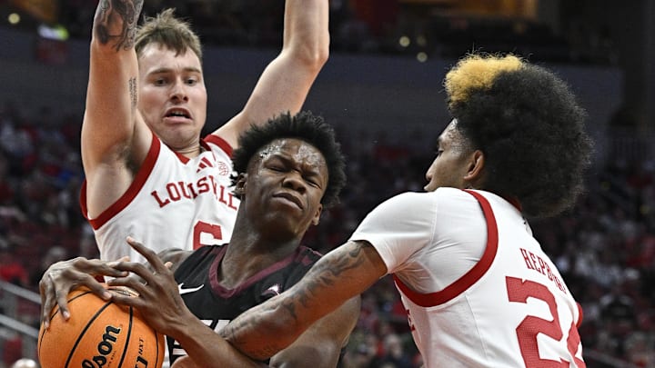 Dec 28, 2024; Louisville, Kentucky, USA;  Eastern Kentucky Colonels guard George Kimble III (3) drives to the basket against  Louisville Cardinals guard Chucky Hepburn (24) and guard Reyne Smith (6) during the first half at KFC Yum! Center. 