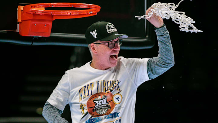 Mar 8, 2026; Kansas City, MO, USA; West Virginia Mountaineers coach Mark Kellogg cuts down the net after the game against the TCU Horned Frogs at T-Mobile Center. Mandatory Credit: William Purnell-Imagn Images