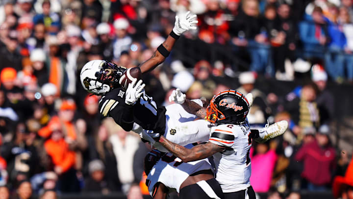 Nov 29, 2024; Boulder, Colorado, USA; Oklahoma State Cowboys cornerback Korie Black (2) and safety Trey Rucker (9) defend on Colorado Buffaloes wide receiver Travis Hunter (12) in the second quarter at Folsom Field. Mandatory Credit: Ron Chenoy-Imagn Images