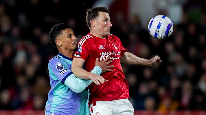 William Saliba (left) challenges Chris Wood (right) for the ball.