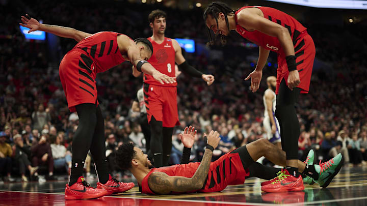 Nov 29, 2024; Portland, Oregon, USA; Portland Trail Blazers guard Anfernee Simons (1) reacts with teammates forward Toumani Camara (33), left, and guard Dalano Banton (5) during the first half against the Sacramento Kings at Moda Center. Mandatory Credit: Troy Wayrynen-Imagn Images