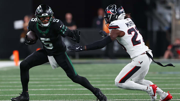 Oct 31, 2024; East Rutherford, New Jersey, USA; New York Jets wide receiver Garrett Wilson (5) runs with the ball against Houston Texans safety Eric Murray (23) during the first half at MetLife Stadium. 