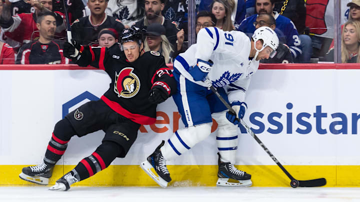 Apr 26, 2025; Ottawa, Ontario, CAN; Toronto Maple Leafs center John Tavares (91) evades a check from Ottawa Senators center Nick Cousins (21) in game four of the first round of the 2025 Stanley Cup Playoffs at Canadian Tire Centre. Mandatory Credit: Marc DesRosiers-Imagn Images