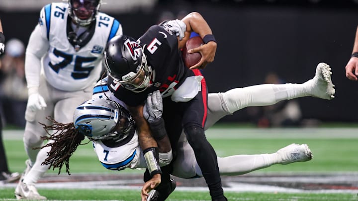 Jan 5, 2025; Atlanta, Georgia, USA; Carolina Panthers linebacker Jadeveon Clowney (7) tackles Atlanta Falcons quarterback Michael Penix Jr. (9) in the third quarter at Mercedes-Benz Stadium. Mandatory Credit: Brett Davis-Imagn Images