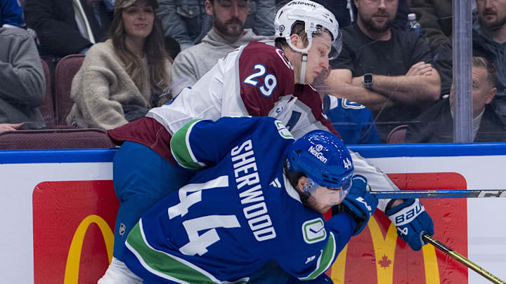 Feb 4, 2025; Vancouver, British Columbia, CAN; Vancouver Canucks forward Kiefer Sherwood (44) cehcks Colorado Avalanche forward Nathan MacKinnon (29) in the second period at Rogers Arena. Mandatory Credit: Bob Frid-Imagn Images
