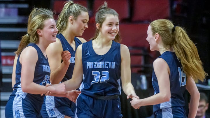 Teammates congratulate Nazareth Academy freshman Stella Sakalas (32) on two points and a foul against Peoria High in the second half of the Class 3A state semifinals Friday, March 3, 2023 at CEFCU Arena in Normal. The Lions ultimately fell to the Roadrunners 48-35.