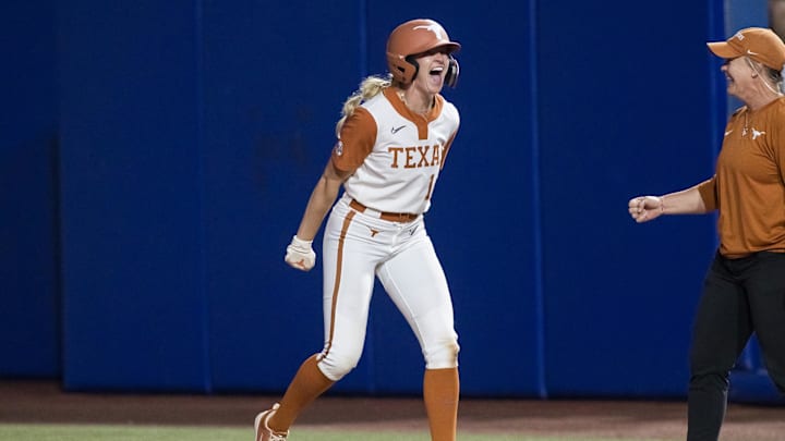Jun 4, 2025; Oklahoma City, OK, USA;  Texas Longhorns utility Reese Atwood (14) yells after hitting an intentional walk pitch for a single and driving in two runs in the sixth inning against the Texas Tech Red Raiders during game one of the NCAA Softball Women's College World Series finals at Devon Park. Mandatory Credit: Brett Rojo-Imagn Images