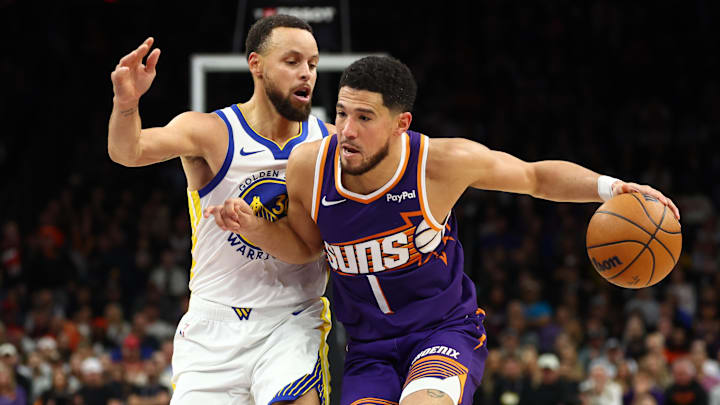 Dec 18, 2025; Phoenix, Arizona, USA; Golden State Warriors guard Stephen Curry (30) defends against Phoenix Suns guard Devin Booker (1) at Mortgage Matchup Center. Mandatory Credit: Mark J. Rebilas-Imagn Images