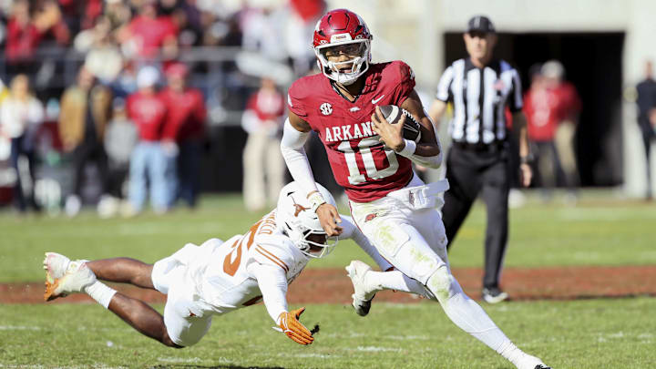 Nov 16, 2024; Fayetteville, Arkansas, USA; Arkansas Razorbacks quarterback Taylen Green (10) rushes in the third quarter as Texas Longhorns defensive back Jelani McDonald (25) defends at Donald W. Reynolds Razorback Stadium. Texas won 20-10. Mandatory Credit: Nelson Chenault-Imagn Images