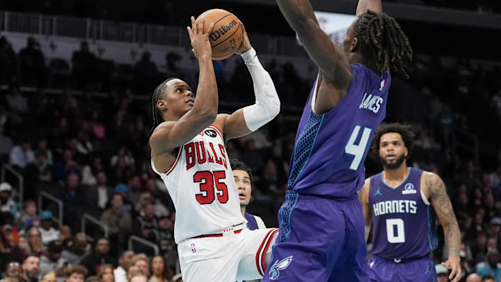 Dec 12, 2025; Charlotte, North Carolina, USA; Chicago Bulls forward Isaac Okoro (35) shoots the ball against Charlotte Hornets guard Sion James (4) during the second half at Spectrum Center. Mandatory Credit: Jim Dedmon-Imagn Images