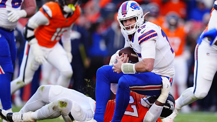 Denver Broncos defensive tackle Malcolm Roach (97) tackles Buffalo Bills quarterback Josh Allen (17) during the second quarter of an AFC Divisional Round playoff game at Empower Field at Mile High. 