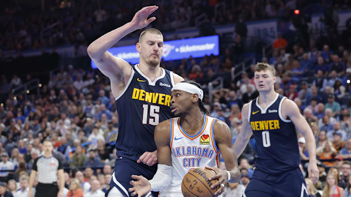 Denver Nuggets center Nikola Jokic (15) defends a drive by Oklahoma City Thunder guard Shai Gilgeous-Alexander (2) during the second half at Paycom Center. 