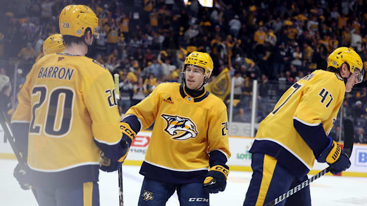 Mar 22, 2025; Nashville, Tennessee, USA; Nashville Predators defenseman Justin Barron (20), Nashville Predators defenseman Spencer Stastney (24) and Nashville Predators right wing Michael McCarron (47) celebrate as their team takes a 5-2 lead at the end of the third period against the Toronto Maple Leafs at Bridgestone Arena. Mandatory Credit: Alan Poizner-Imagn Images