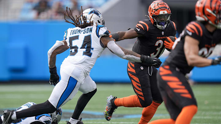 Sep 29, 2024; Charlotte, North Carolina, USA; Cincinnati Bengals running back Zack Moss (31) tries to elude Carolina Panthers linebacker Shaq Thompson (54) during the third quarter at Bank of America Stadium. Mandatory Credit: Jim Dedmon-Imagn Images