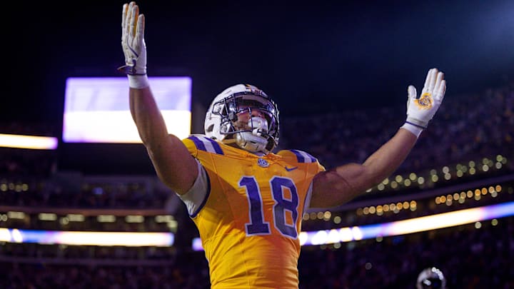 Nov 23, 2024; Baton Rouge, Louisiana, USA; LSU Tigers running back Josh Williams (18) scores a touchdown against Vanderbilt Commodores linebacker Bryan Longwell (4) during the first half at Tiger Stadium. Mandatory Credit: Stephen Lew-Imagn Images Nov 23, 2024; Baton Rouge, Louisiana, USA; LSU Tigers running back Josh Williams (18) scores a touchdown against Vanderbilt Commodores linebacker Bryan Longwell (4) during the first half at Tiger Stadium. Mandatory Credit: Stephen Lew-Imagn Images
