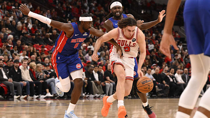 Oct 22, 2025; Chicago, Illinois, USA; Chicago Bulls guard Josh Giddey (3) drives between Detroit Pistons guard Caris LeVert (8) and forward Isaiah Stewart (28) during the first half at United Center. Mandatory Credit: Matt Marton-Imagn Images