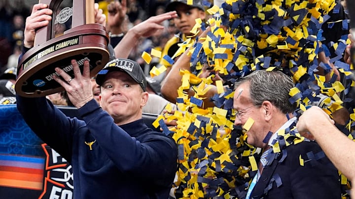 Michigan head coach Dusty May hoists up the NCAA Tournament Midwest Regional Championship trophy after 95-62 win over Tennessee at United Center in Chicago on Sunday, March 29, 2026.