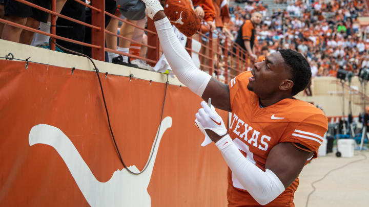 April 20, 2024; Austin, Texas, USA: Texas Orange team defensive back Terrance Brooks (8) signs autographs for fans while visiting for the Longhorns' spring Orange and White game at Darrell K Royal Texas Memorial Stadium. Mandatory Credit: Sara Diggins-USA Today Sports via American Statesman
