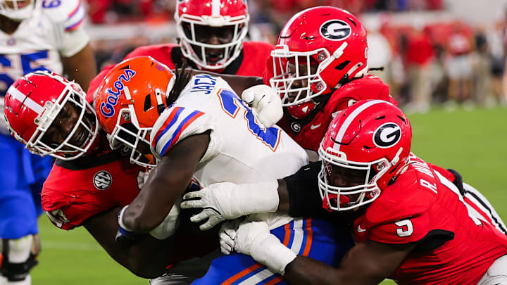 Georgia Bulldogs defensive lineman Mykel Williams (13) wraps up Florida Gators running back Ja'Kobi Jackson (24) Georgia Bulldogs defensive lineman Mykel Williams (13) wraps up Florida Gators running back Ja'Kobi Jackson (24)
