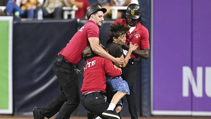 Aug 19, 2025; A young fan is tackled by security guards after running on the field during the eighth inning in a game between the San Diego Padres and the San Francisco Giants at Petco Park.
