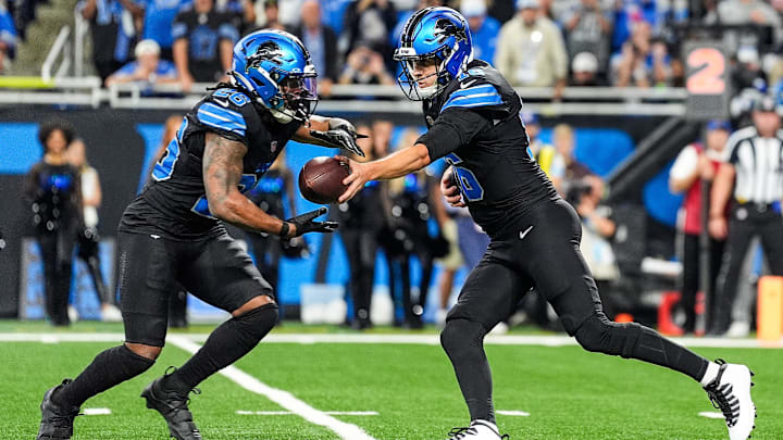 Detroit Lions quarterback Jared Goff (16) hands the ball to running back Jahmyr Gibbs (26).