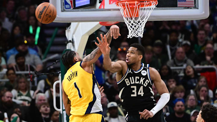 Apr 27, 2025; Milwaukee, Wisconsin, USA: Milwaukee Bucks forward Giannis Antetokounmpo (34) and Indiana Pacers forward Obi Toppin (1) reach for the ball in the third quarter during game four of first round for the 2024 NBA Playoffs at Fiserv Forum. Mandatory Credit: Benny Sieu-Imagn Images