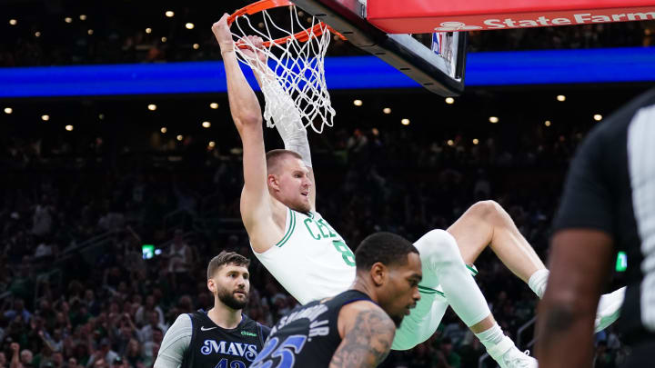 Jun 6, 2024; Boston, Massachusetts, USA; Boston Celtics center Kristaps Porzingis (8) dunks against Dallas Mavericks forward P.J. Washington (25) and forward Maxi Kleber (42) in the third quarter during game one of the 2024 NBA Finals at TD Garden. Mandatory Credit: David Butler II-USA TODAY Sports