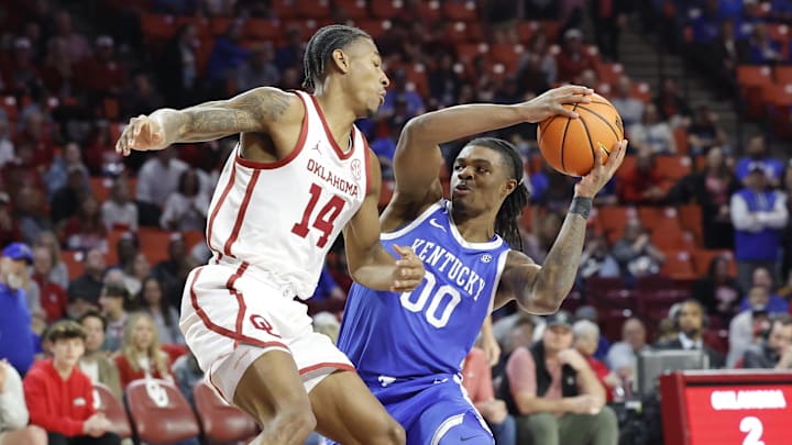 Feb 26, 2025; Norman, Oklahoma, USA; Oklahoma Sooners forward Jalon Moore (14) defends a drive by Kentucky Wildcats guard Otega Oweh (00) during the first half at Lloyd Noble Center. Mandatory Credit: Alonzo Adams-Imagn Images
