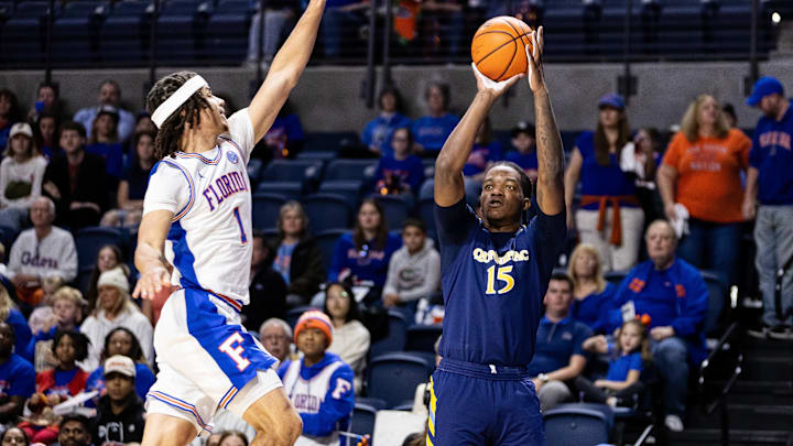 Dec 30, 2023; Gainesville, Florida, USA; Florida Gators guard Walter Clayton Jr. (1) attempts to block a shot from Quinnipiac Bobcats forward Amarri Tice (15) during the first half at Exactech Arena at the Stephen C. O'Connell Center. Mandatory Credit: Matt Pendleton-Imagn Images