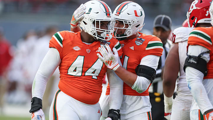 Dec 28, 2023; Bronx, NY, USA; Miami Hurricanes defensive lineman Rueben Bain Jr. (44) and linebacker Francisco Mauigoa (51) celebrates after a defensive stop during the first half of the 2023 Pinstripe Bowl against the Rutgers Scarlet Knights at Yankee Stadium. Mandatory Credit: Vincent Carchietta-Imagn Images