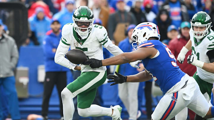 Dec 29, 2024; Orchard Park, New York, USA; Buffalo Bills defensive tackle Ed Oliver (91) punches the ball out from New York Jets wide receiver Garrett Wilson (5)  to cause a fumble in the third quarter at Highmark Stadium. Mandatory Credit: Mark Konezny-Imagn Images