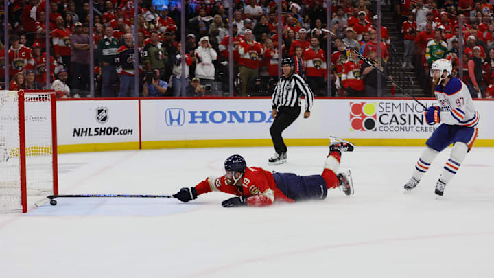 Florida Panthers forward Matthew Tkachuk reaches for the puck on an empty net attempt on goal by Edmonton Oilers forward Connor McDavid during the 2024 Stanley Cup Final