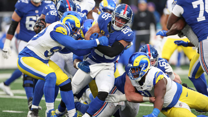 Dec 31, 2023; East Rutherford, New Jersey, USA; New York Giants running back Saquon Barkley (26) is tackled by Los Angeles Rams defensive tackle Aaron Donald (99) during the second half at MetLife Stadium. Mandatory Credit: Vincent Carchietta-USA TODAY Sports Dec 31, 2023; East Rutherford, New Jersey, USA; New York Giants running back Saquon Barkley (26) is tackled by Los Angeles Rams defensive tackle Aaron Donald (99) during the second half at MetLife Stadium. Mandatory Credit: Vincent Carchietta-USA TODAY Sports