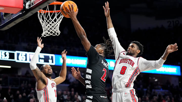 Cincinnati Bearcats guard Jizzle James (2) rises to the basket as Houston Cougars guard Mylik Wilson (8) defends in the second half of an NCAA college basketball game between the Houston Cougars and the Cincinnati Bearcats, Saturday, Feb. 10, 2024, at Fifth Third Arena in Cincinnati. Cincinnati Bearcats guard Jizzle James (2) rises to the basket as Houston Cougars guard Mylik Wilson (8) defends in the second half of an NCAA college basketball game between the Houston Cougars and the Cincinnati Bearcats, Saturday, Feb. 10, 2024, at Fifth Third Arena in Cincinnati.