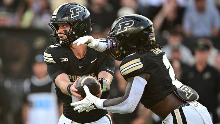 Purdue Boilermakers quarterback Ryan Browne (15) hands the ball to running back Fame Ijeboi (2). Purdue Boilermakers quarterback Ryan Browne (15) hands the ball to running back Fame Ijeboi (2).