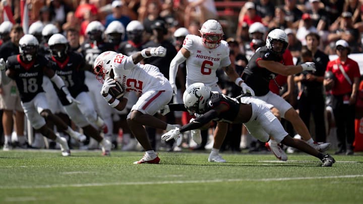 Houston Cougars defensive back Bryan Massey (22) returns a kickoff as Cincinnati Bearcats safety Ken Willis (27) attempts to tackle him in the third quarter of the College Football game at Nippert Stadium in Cincinnati on Saturday, Sept. 21, 2024.