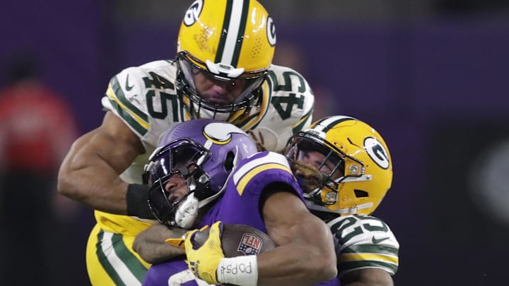 Minnesota Vikings running back Aaron Jones is tackled by Green Bay Packers defenders Keisean Nixon (25) and Eric Wilson.