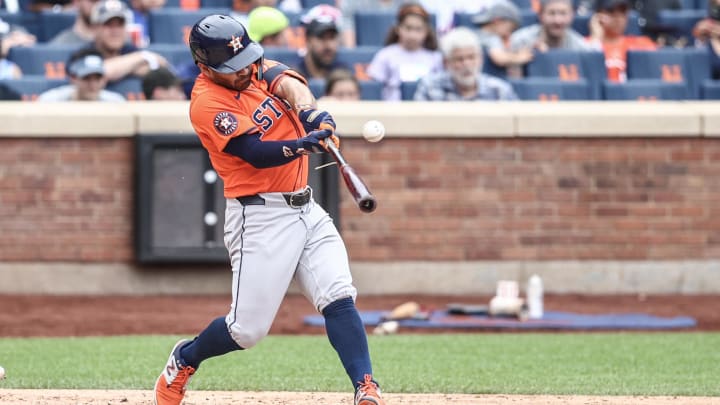 Jun 30, 2024; New York City, New York, USA;  Houston Astros second baseman Jose Altuve (27) hits an RBI single in the fifth inning against the New York Mets at Citi Field. 