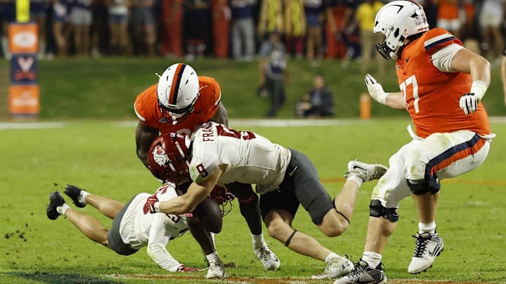 Oct 18, 2025; Charlottesville, Virginia, USA; Virginia Cavaliers running back Harrison Waylee (21) fumbles the ball after a hit by Washington State Cougars safety Cale Reeder (25) in the fourth quarter at Scott Stadium. Mandatory Credit: Geoff Burke-Imagn Images